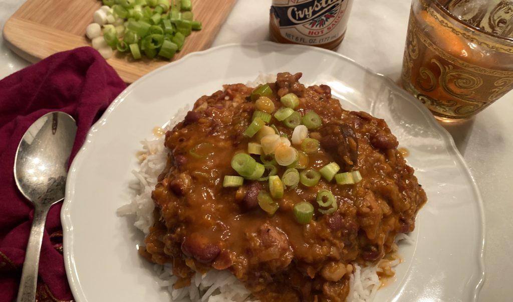 red beans and rice, garnished with green onions, and crystal hotsauce and sazerac to wash it down